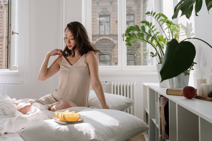 Morning light through a bedroom window with a quiet plant and ceramic mug